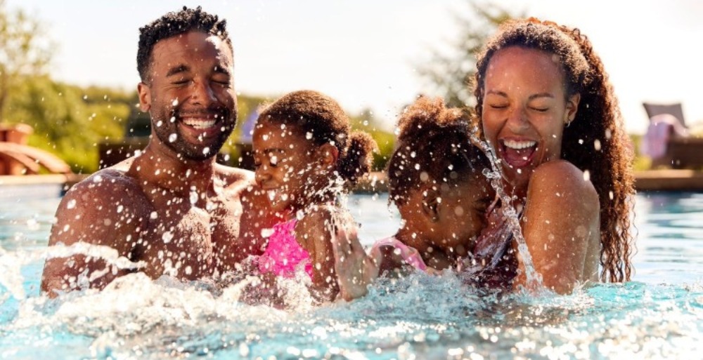 Family of four splashing in the pool